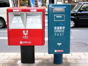 通常の赤い郵便ポストと速達郵便用の青い郵便ポストの画像